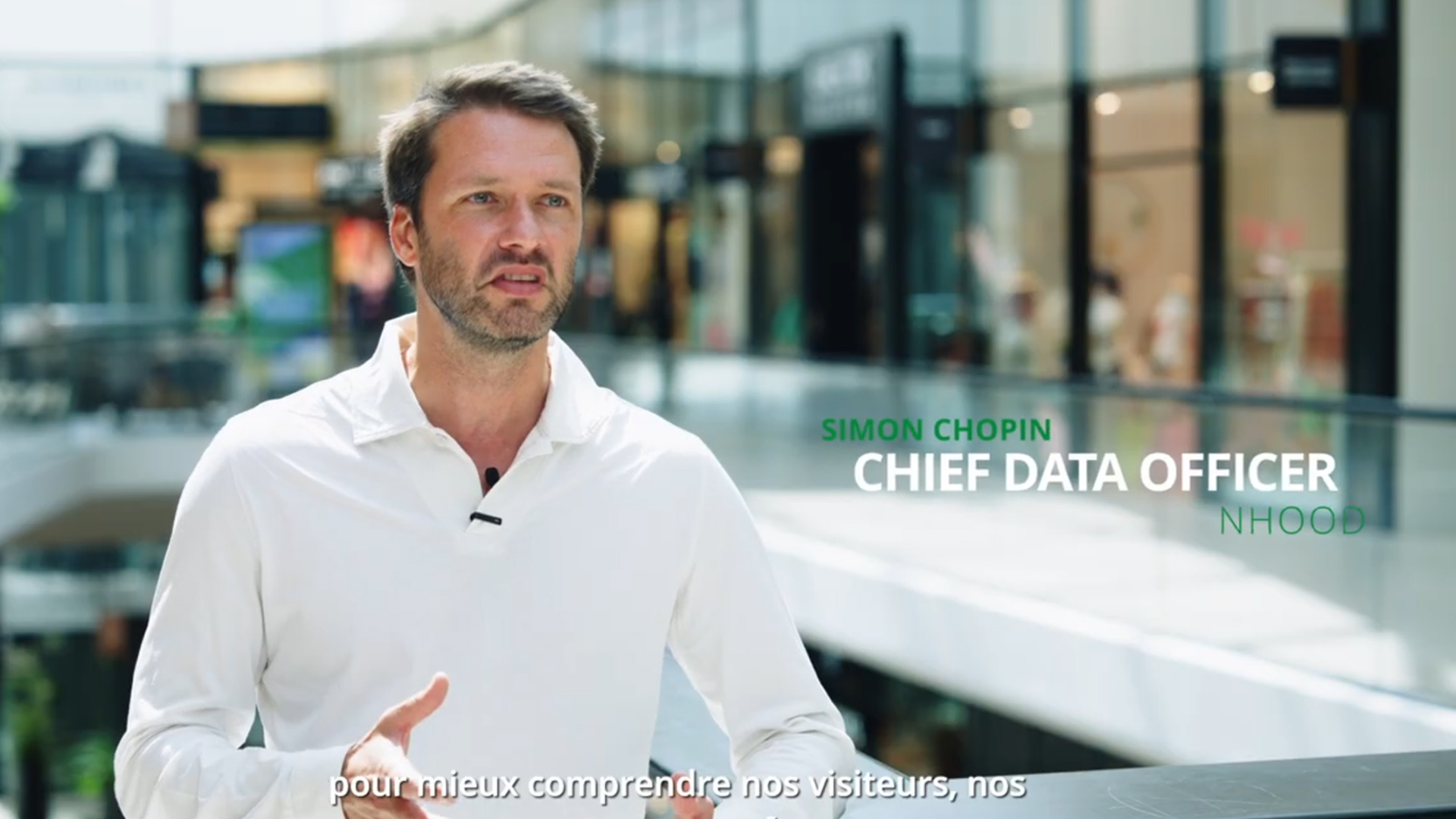 Interview vidéo d’un responsable data dans un centre commercial, avec texte à l’écran indiquant “Chief Data Officer – Nhood”, utilisée pour illustrer l’usage de l’analyse de données dans le retail.