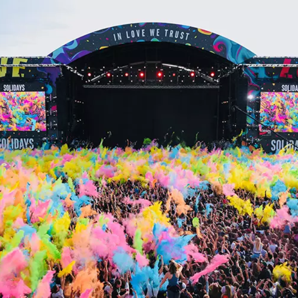 Foule en liesse devant la grande scène du festival Solidays 2025, baignée de nuages colorés, symbole de l’énergie, de la diversité et de la gestion fluide des flux grâce à la technologie CORE de XXII (22).